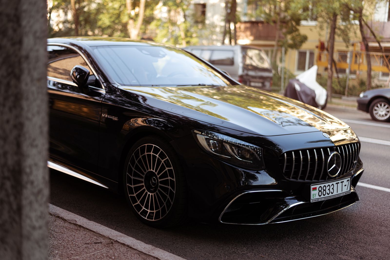 Luxury black car parked on an urban street, displaying elegance and sophistication.