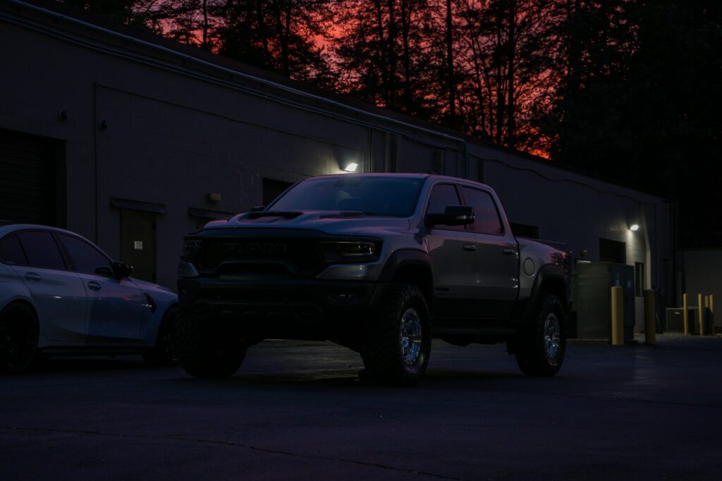 A gray pickup truck parked outside a building at dusk.