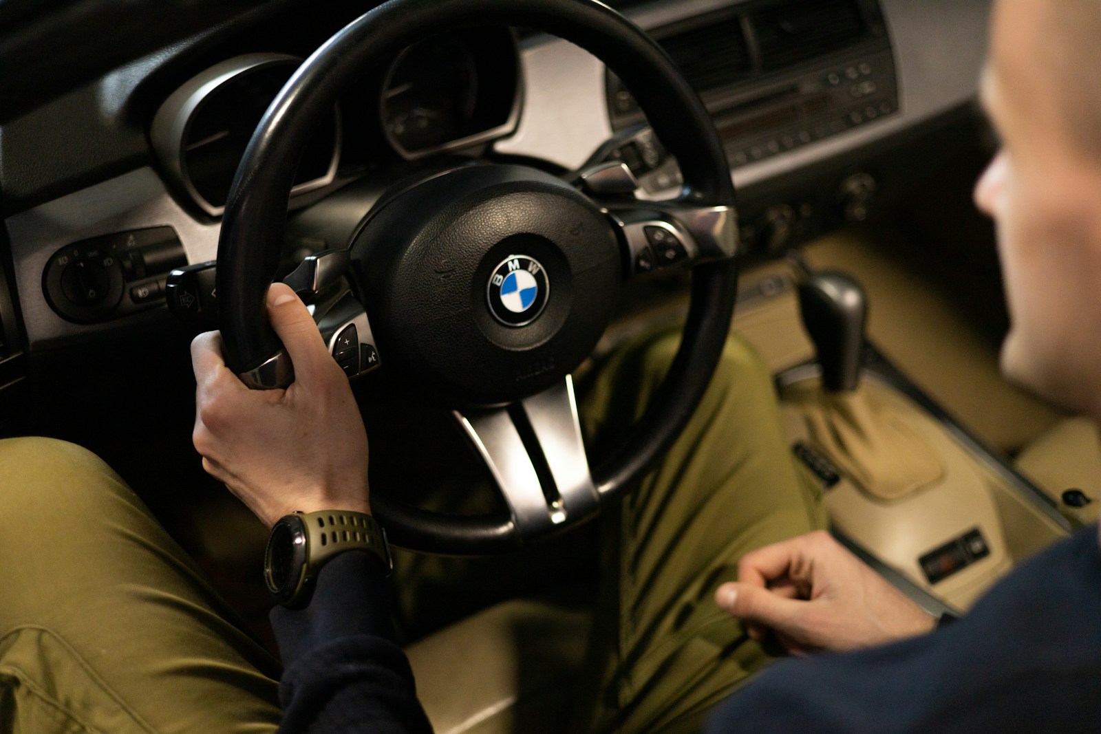 a man sitting in a car holding a steering wheel