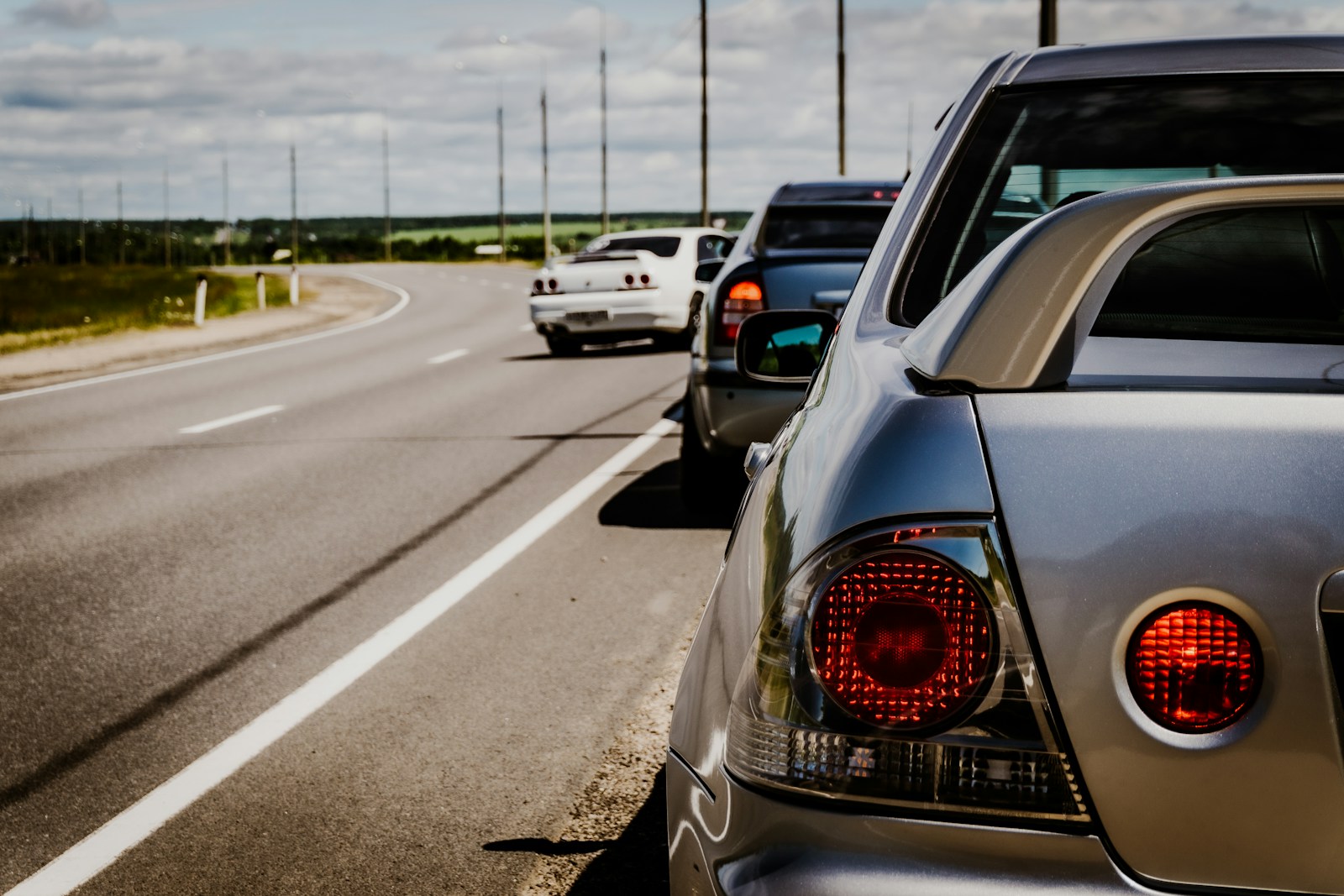 Cars stopped on the side of a highway.