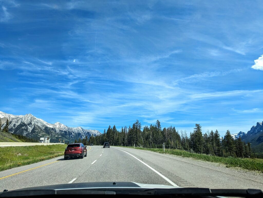 A car driving down a road with mountains in the background