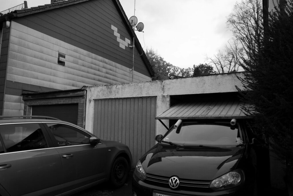 Two cars parked in front of a garage.