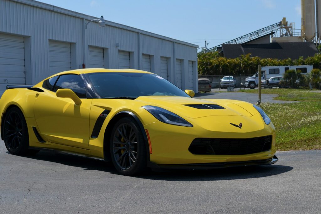 a yellow sports car parked in front of a building