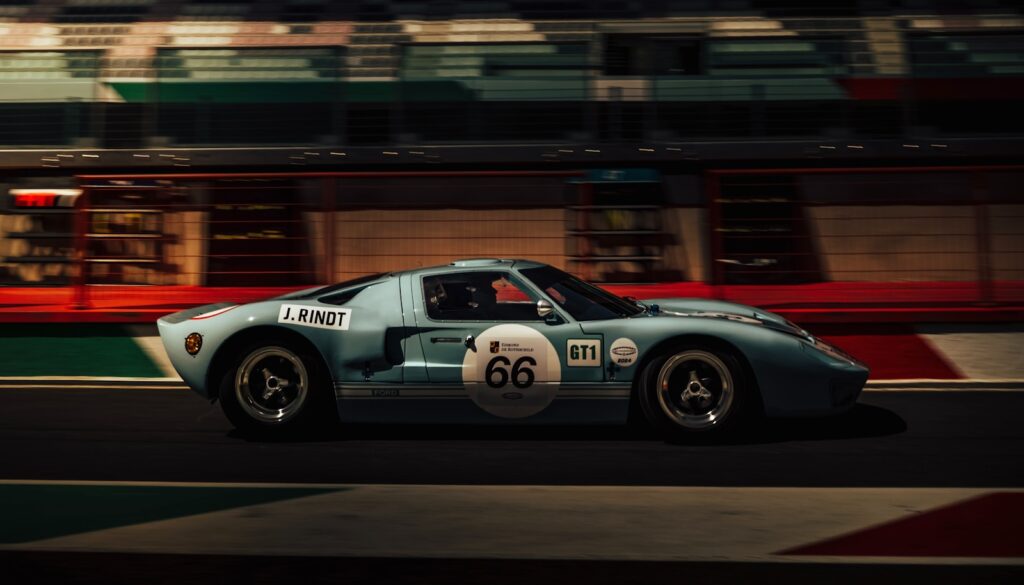 a blue race car driving down a race track