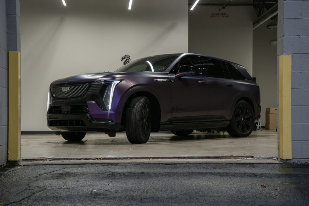 A purple cadillac suv parked in a garage