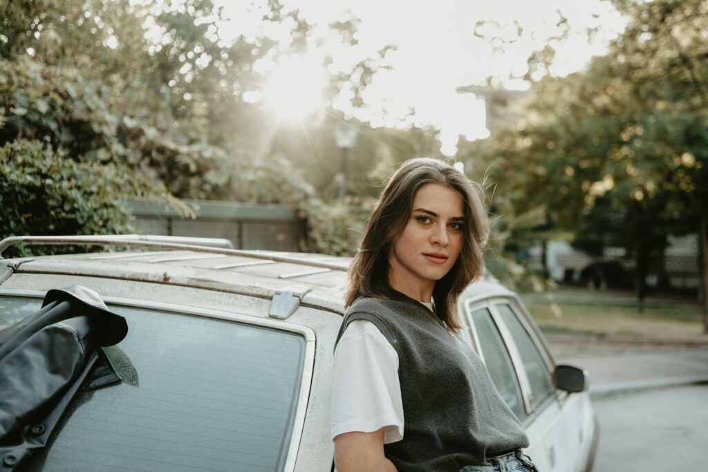 a woman standing next to a parked car