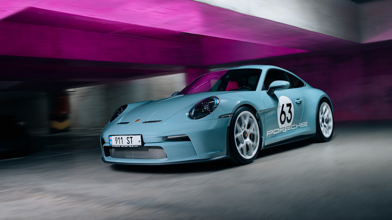 A blue sports car parked in a parking garage