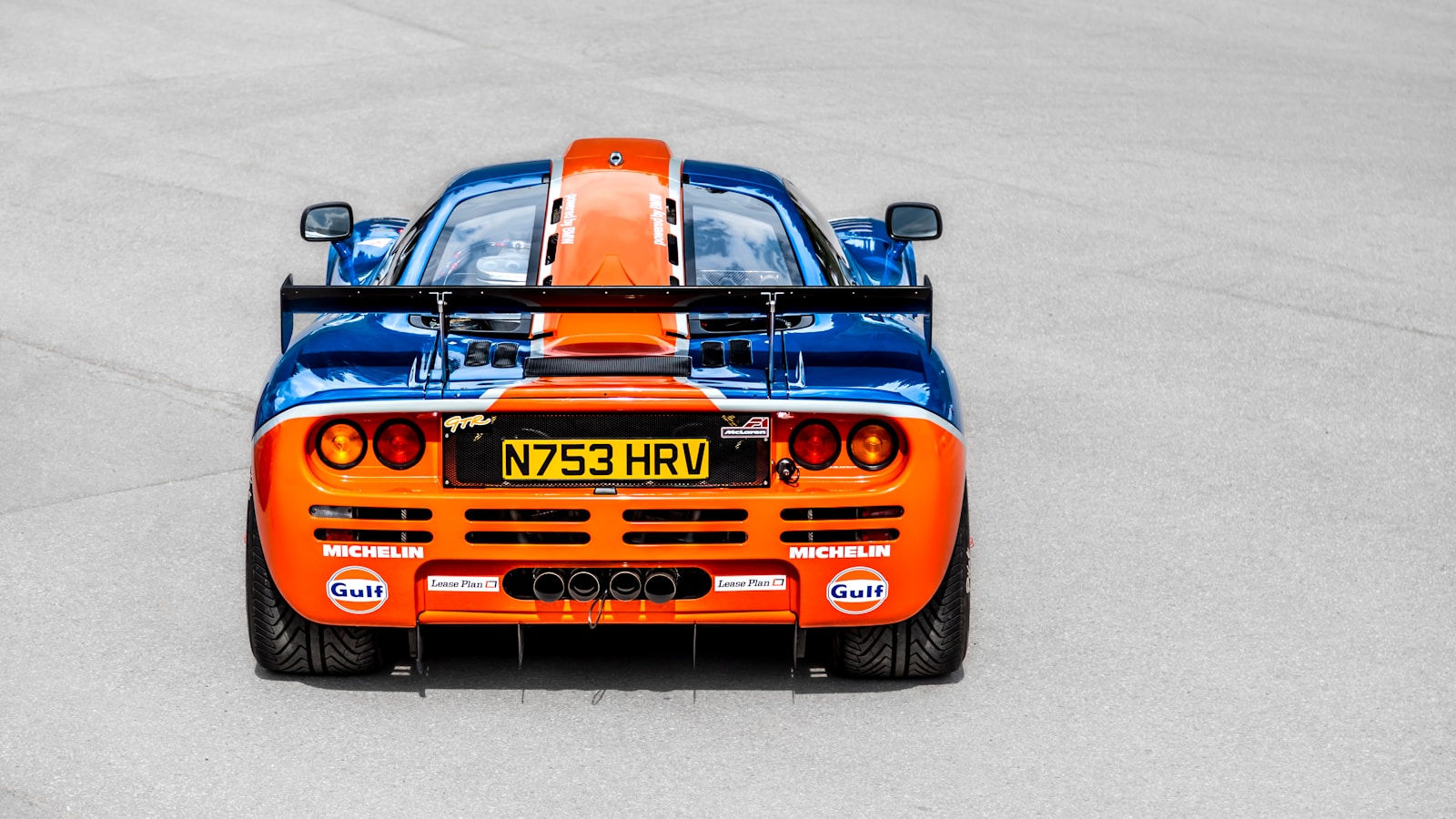 An orange and blue race car on a race track