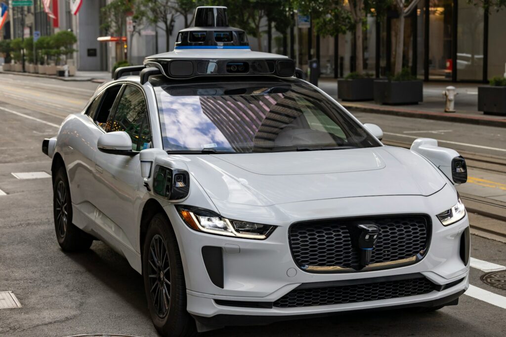 A white self-driving car on a city street