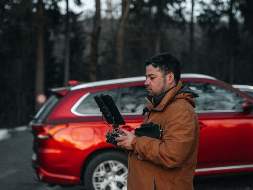a man standing in front of a red car