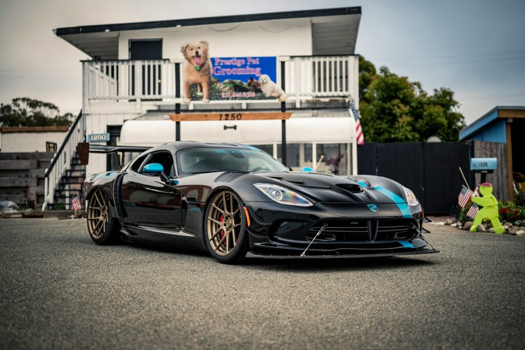 Black dodge viper with blue stripes parked