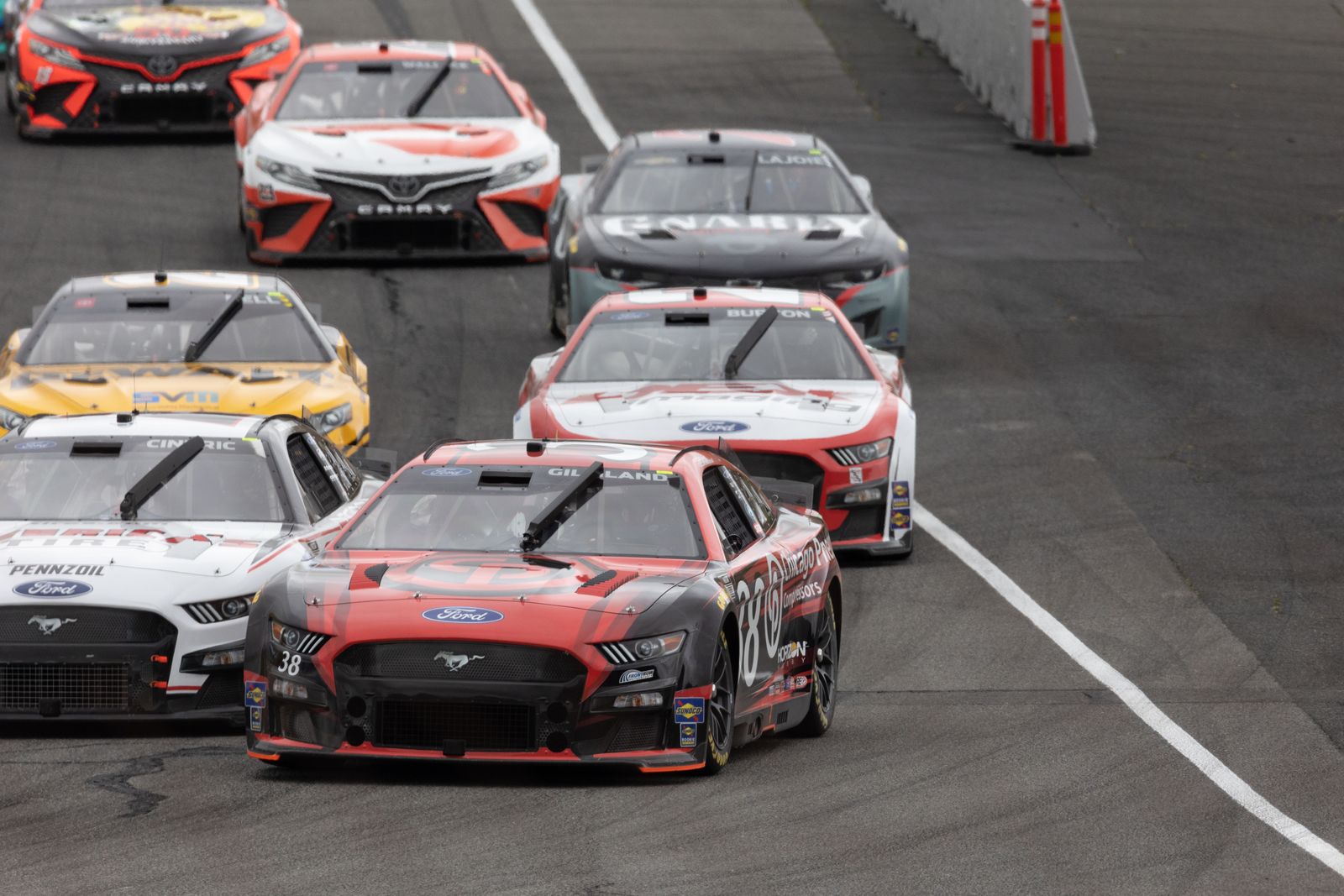 Dynamic scene of multiple racing cars competing on an outdoor track.