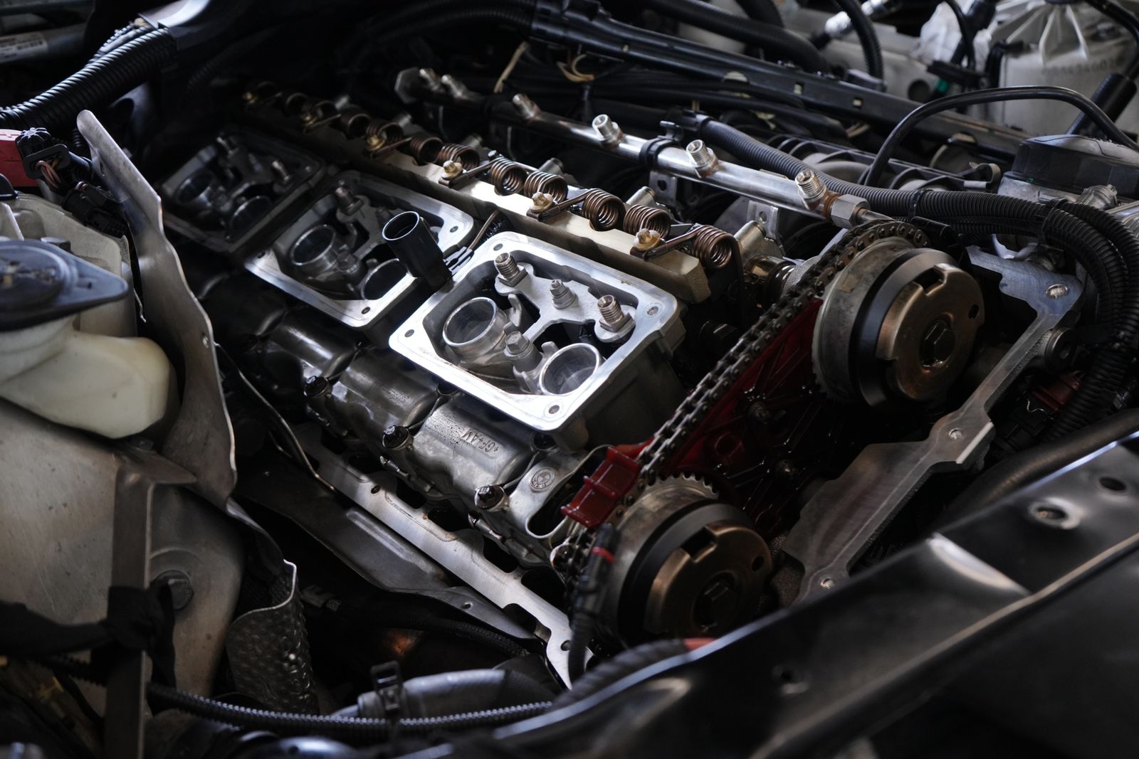 Detailed view of car engine undergoing repair, showcasing intricate mechanical parts.