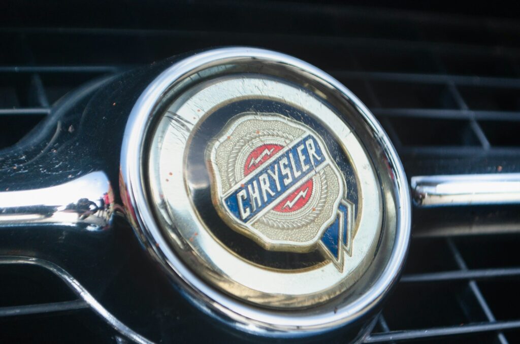A vintage Chrysler emblem with a chrome border on a black grille