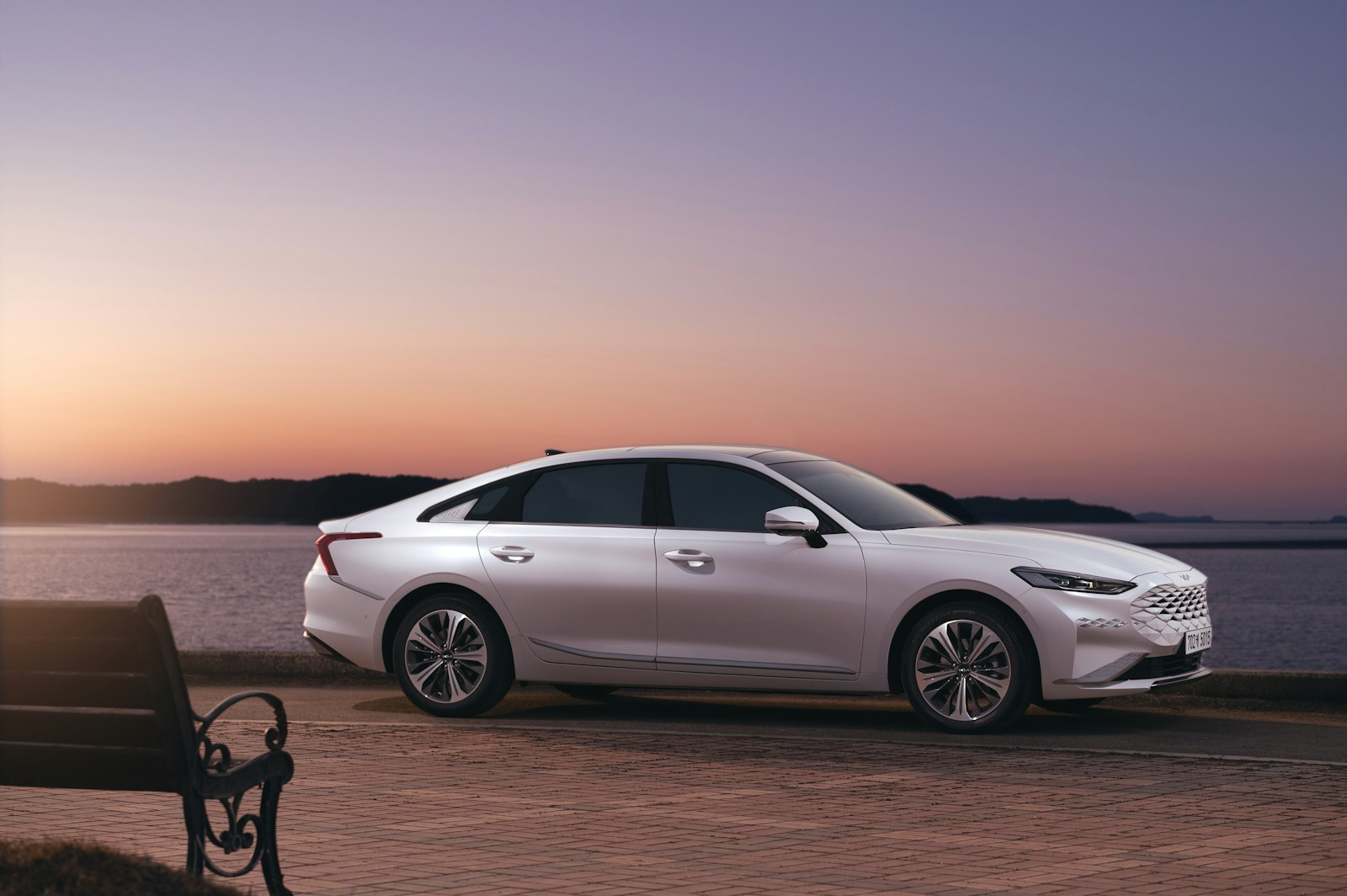 a white car parked next to a body of water