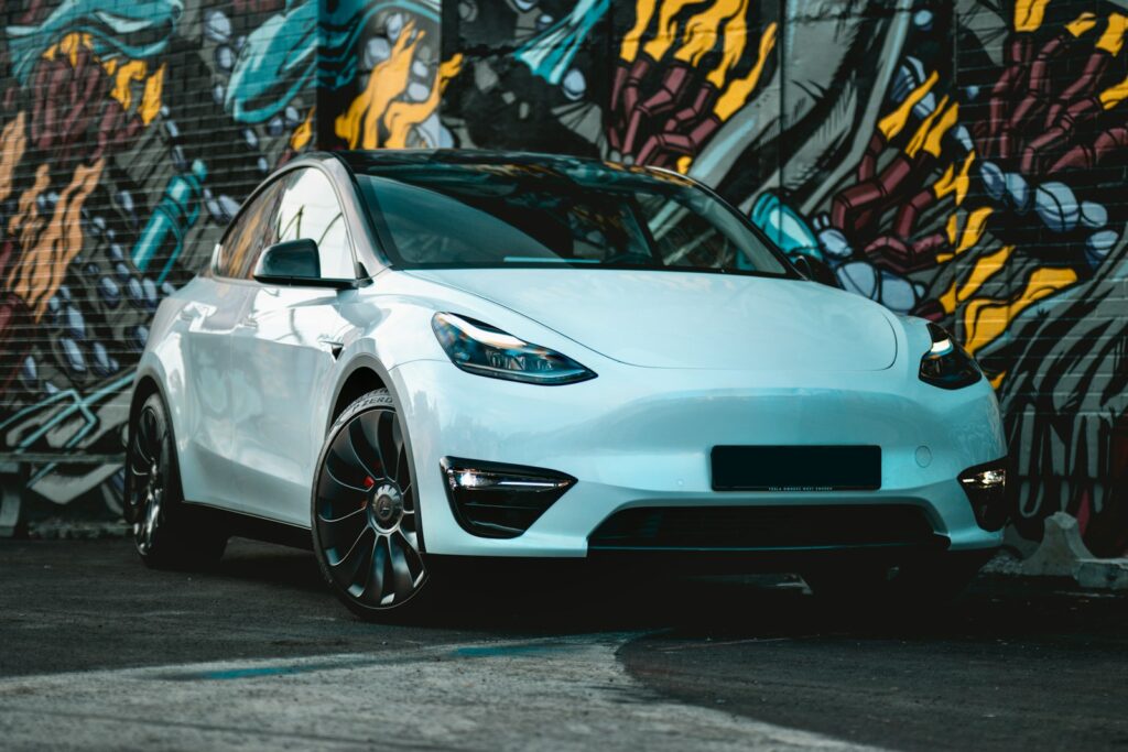 a white car parked in front of a graffiti covered wall