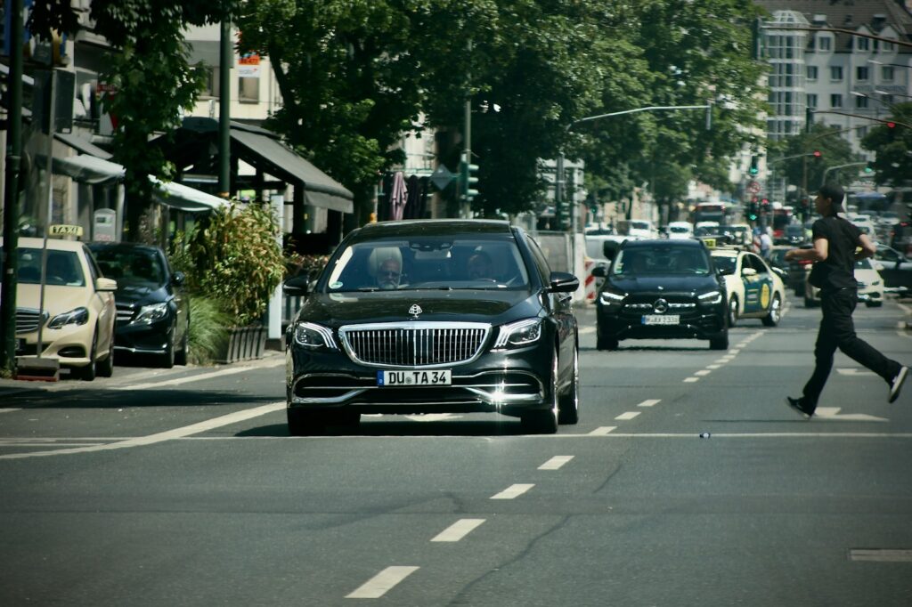 A man walking across a street next to a car