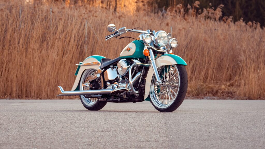 blue and silver cruiser motorcycle on gray asphalt road during daytime