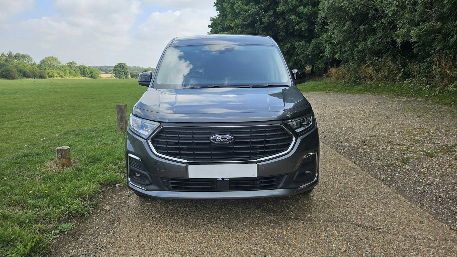 Dark grey van parked on gravel path outdoors