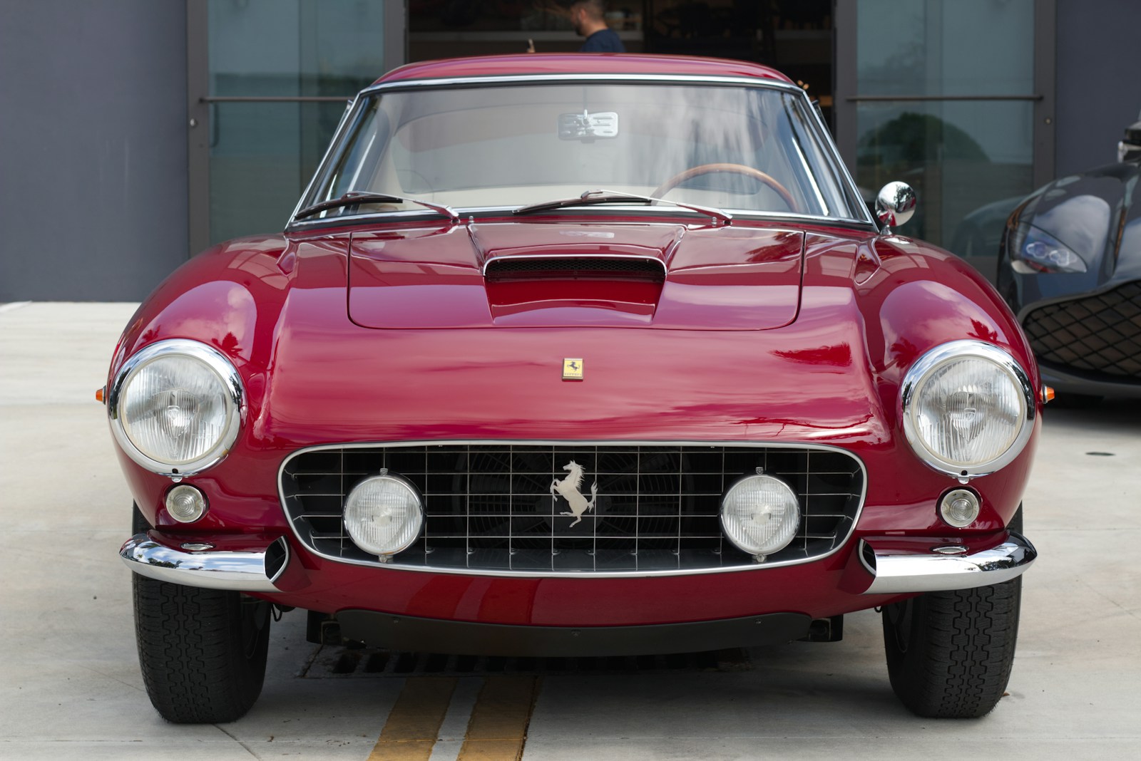 A classic red ferrari parked outside a building