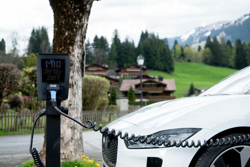 White electric car charging in a scenic mountain village