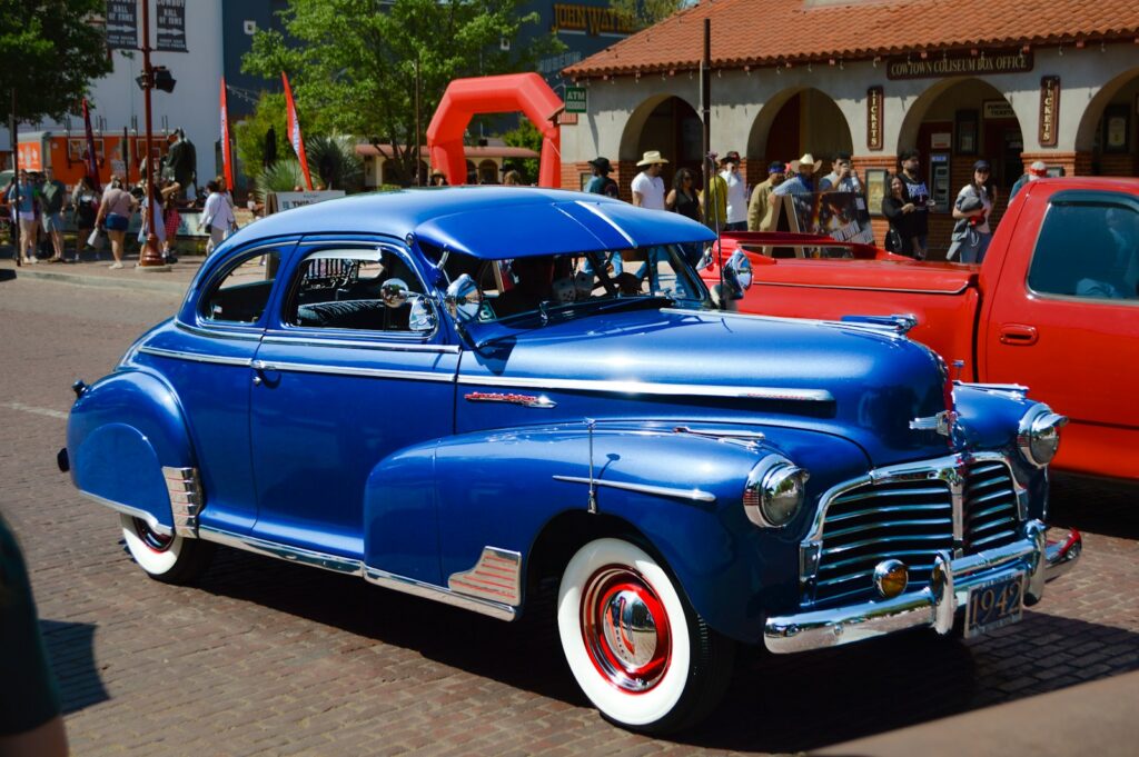 A shiny blue vintage car parked on a street