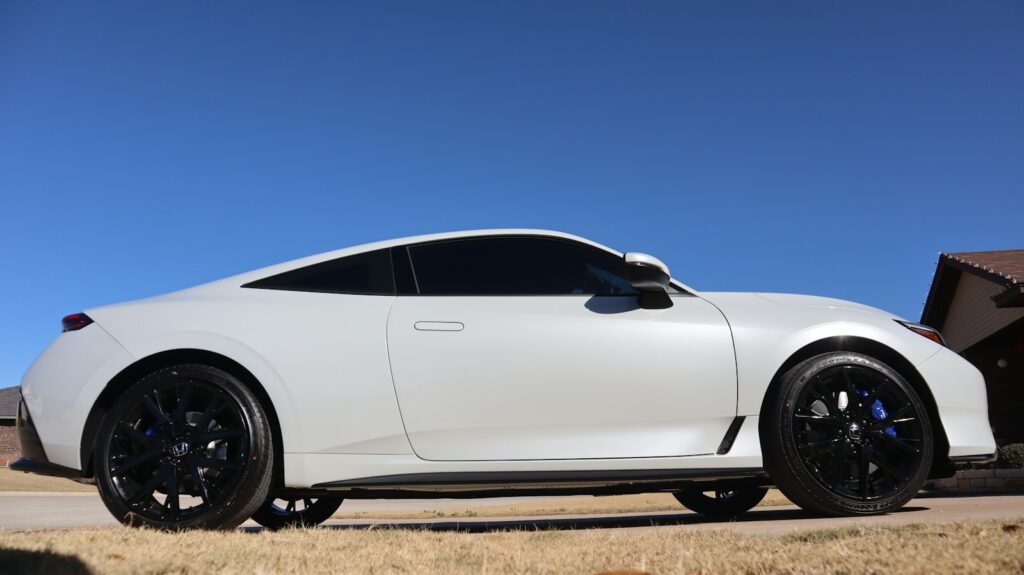 White sports car parked under a clear blue sky