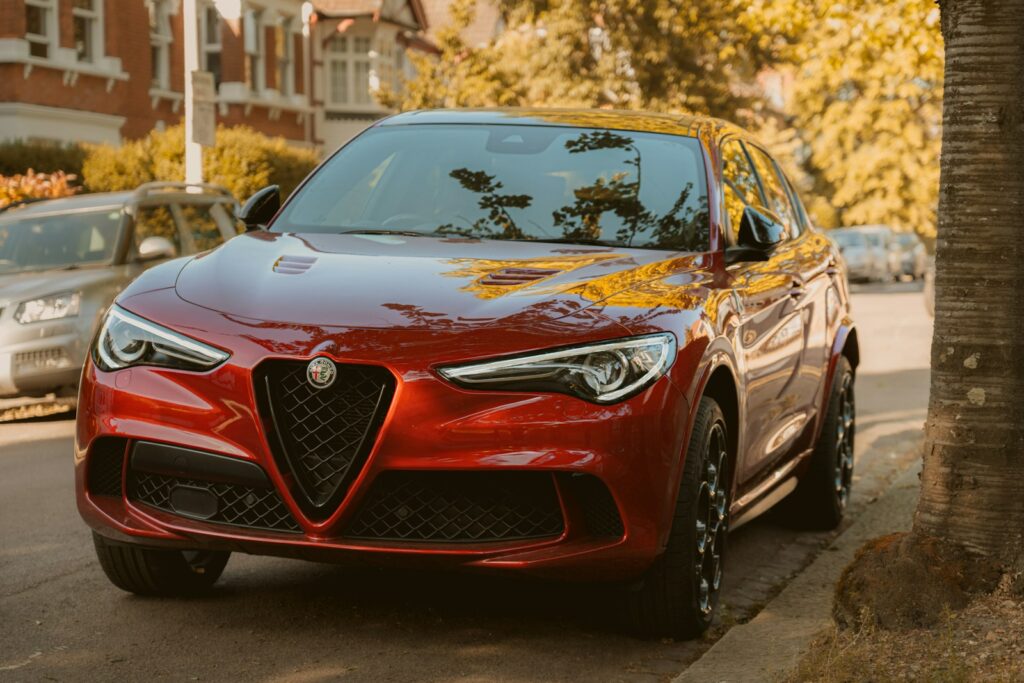 A red alfa romeo suv is parked on the street