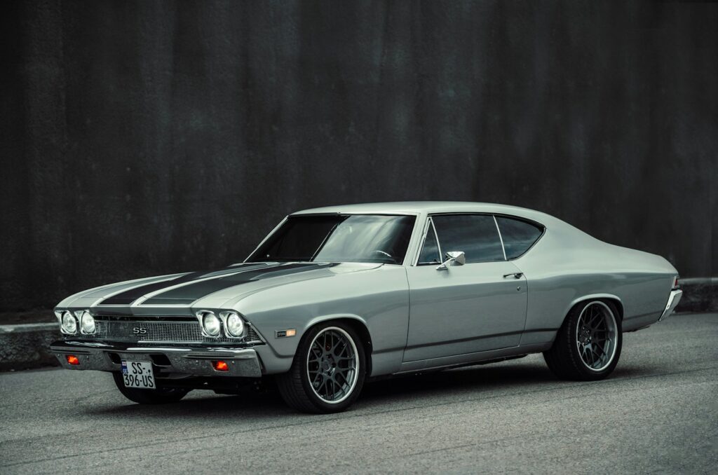 A classic silver muscle car with black racing stripes