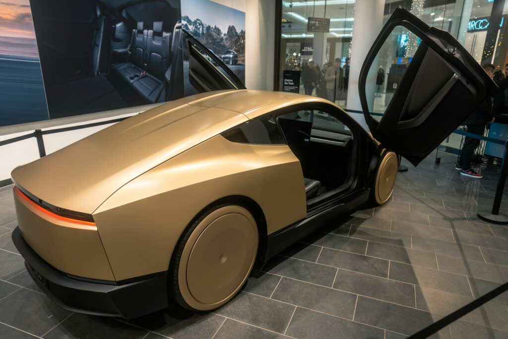 A gold colored car on display in a building
