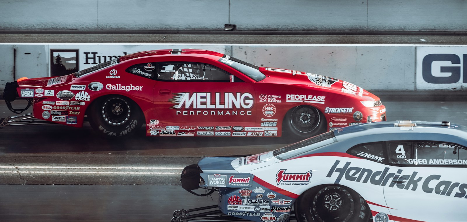 a red car with a white car behind it on a track