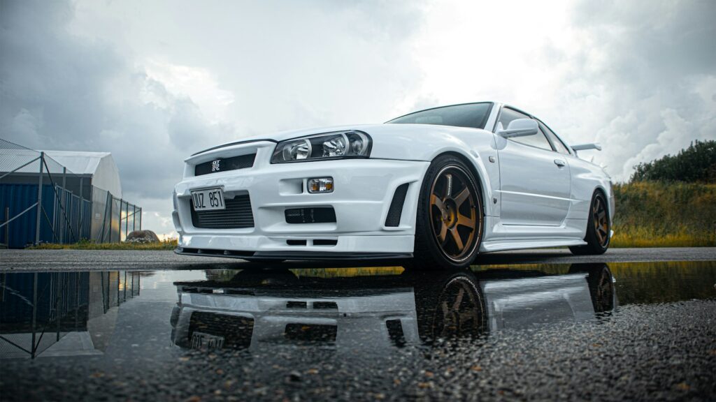 a white sports car parked on a wet road