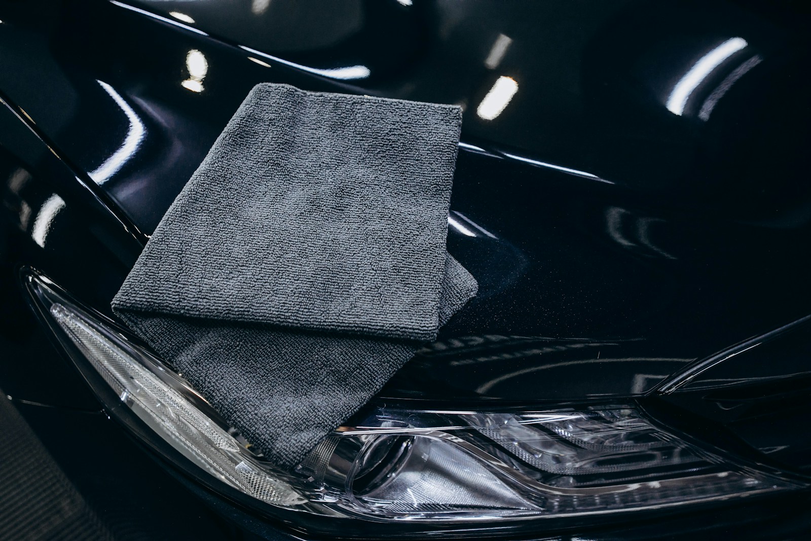 Gray microfiber cloth on a black car hood