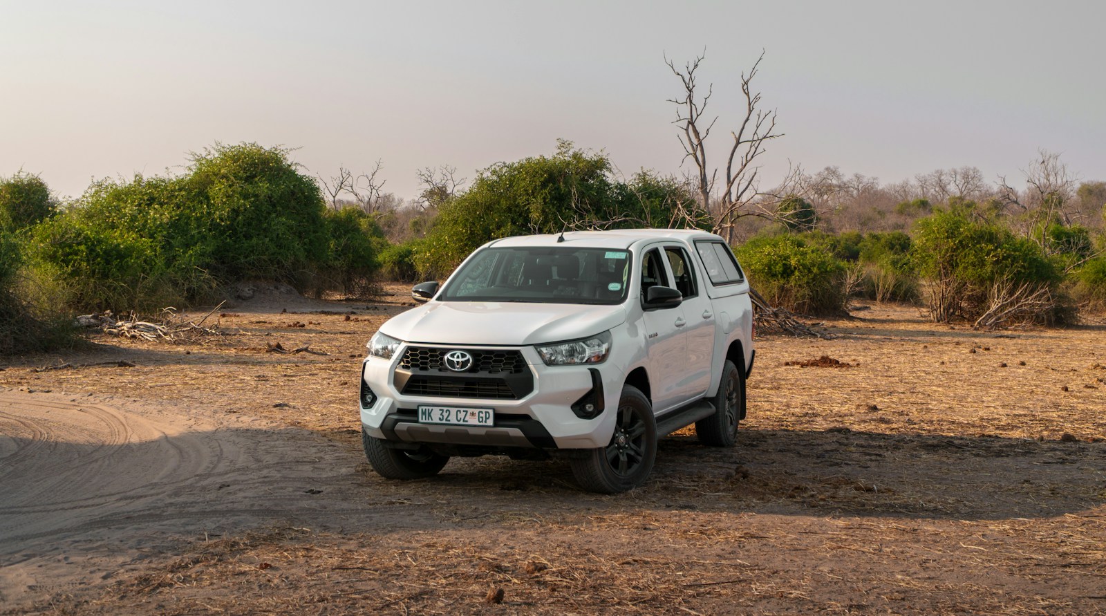 White pickup truck parked in a dry, dusty landscape
