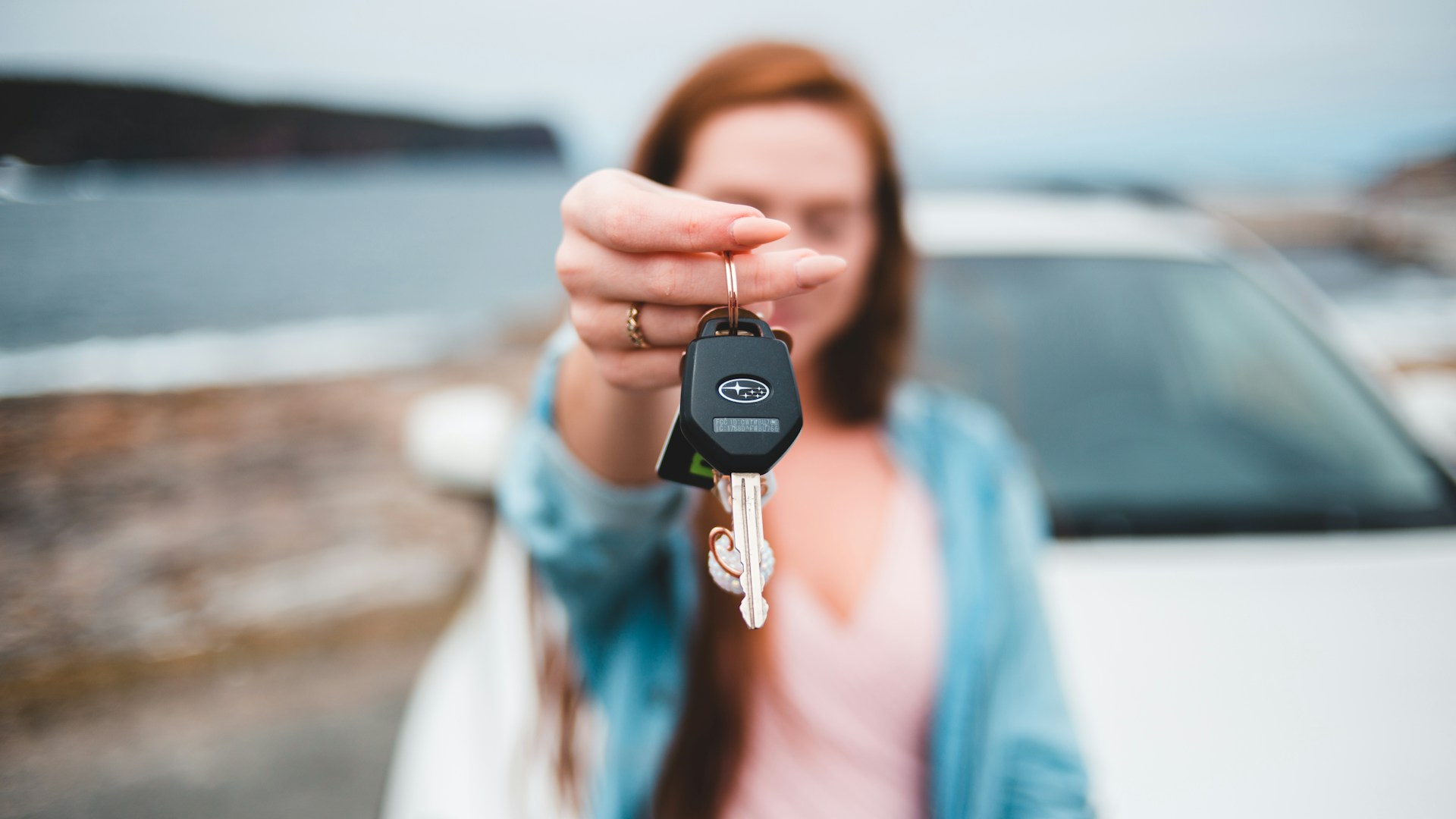 A black vehicle key fob on a light surface.