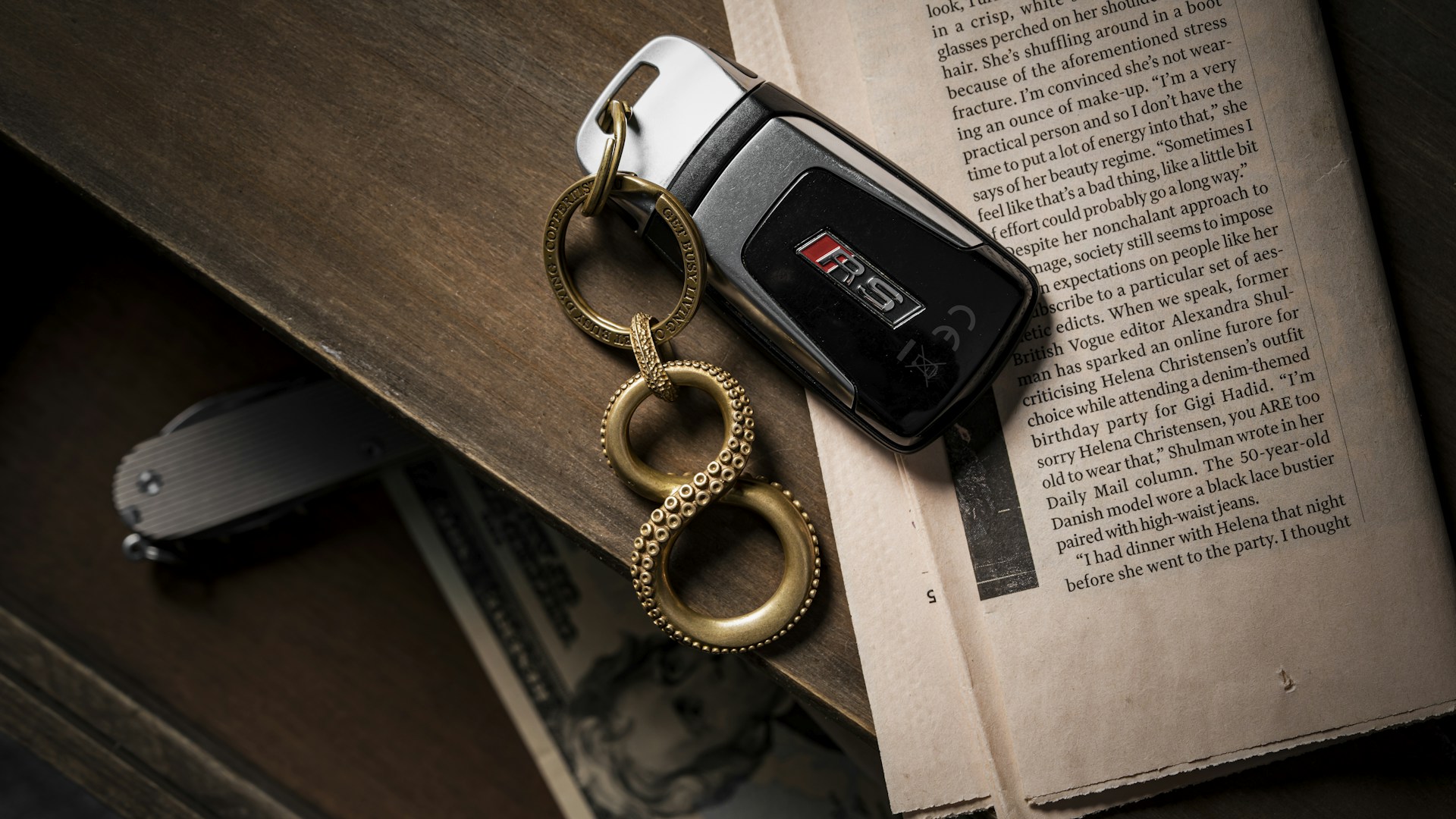 A car keychain rests on top of a book.